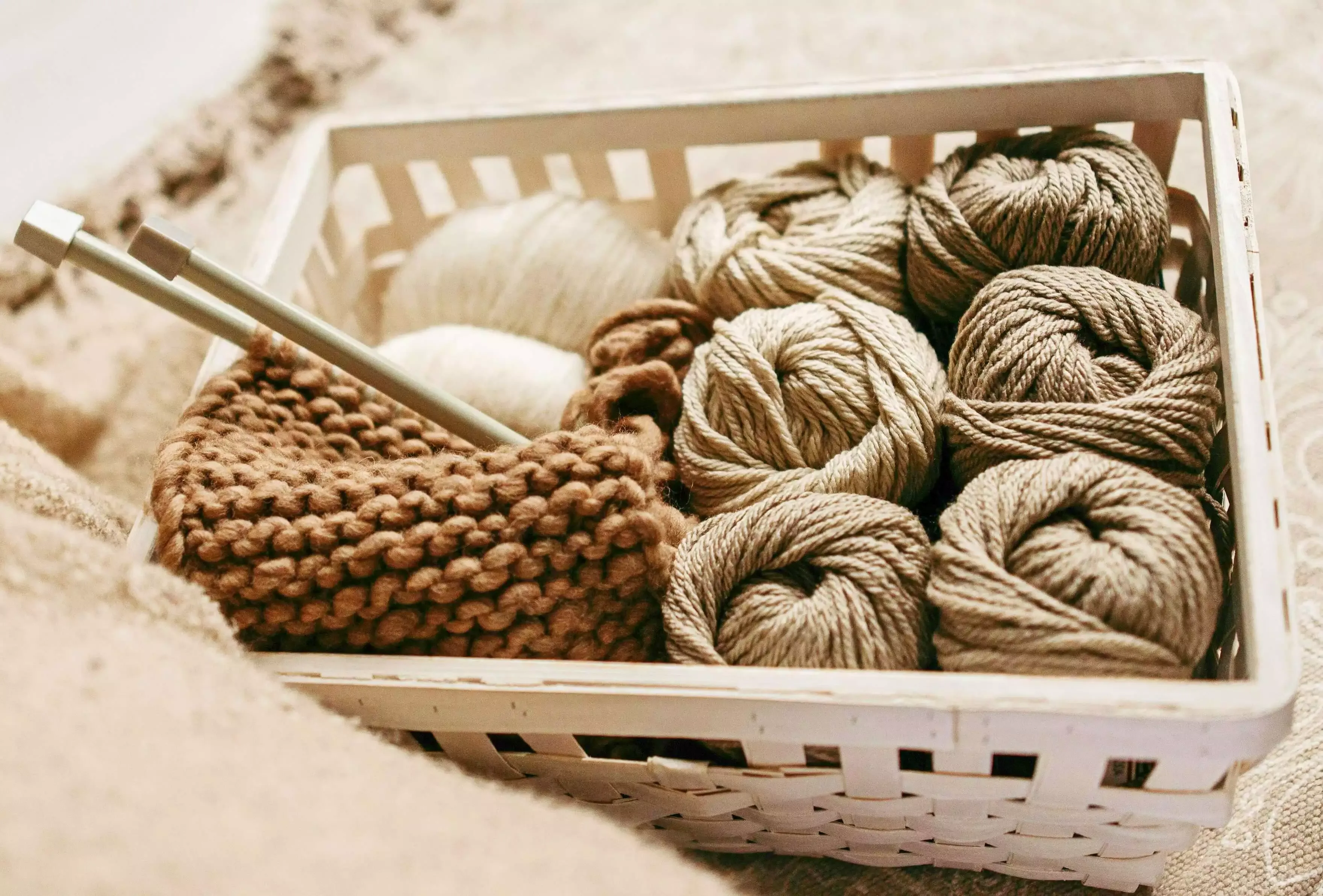 Dự án đan len với sợi len mềm mại đặt trong giỏ mây trang trí